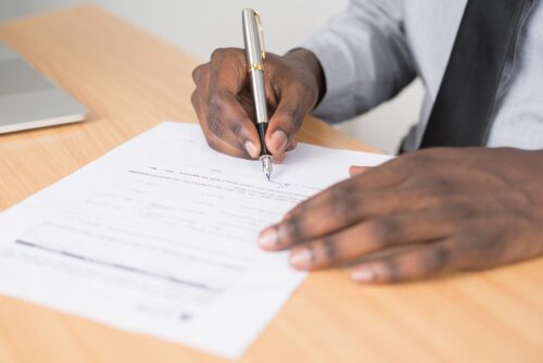 man signing document